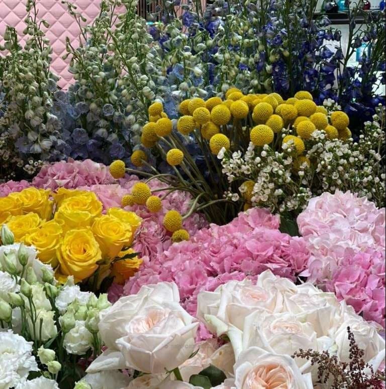 Close view of yellow roses, pink hydrangea and white flowers