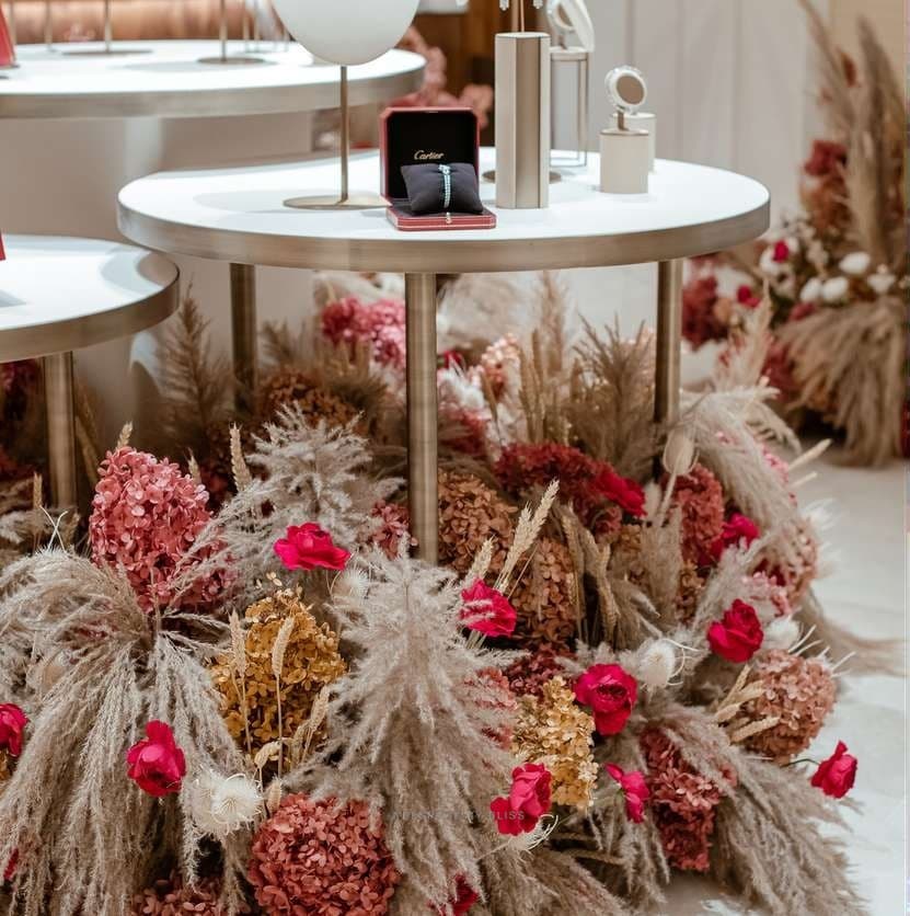 Pampas grass, dried hydrangea and red flowers around a round display table